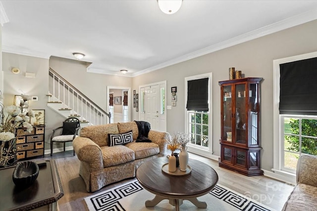 living area featuring ornamental molding, stairs, light wood-style floors, and baseboards