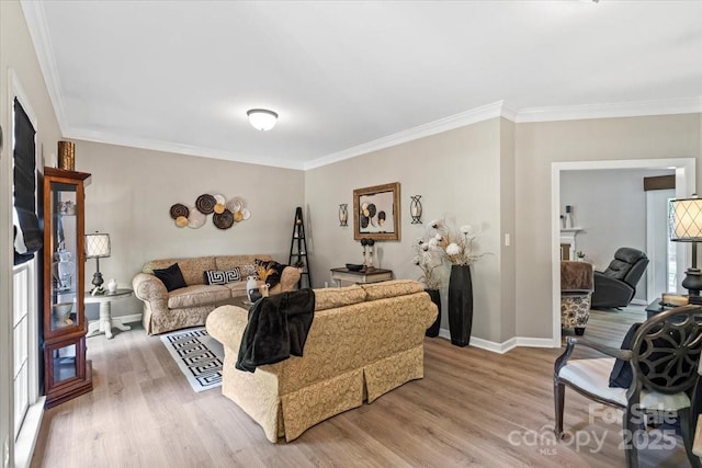 living room with crown molding, baseboards, and wood finished floors