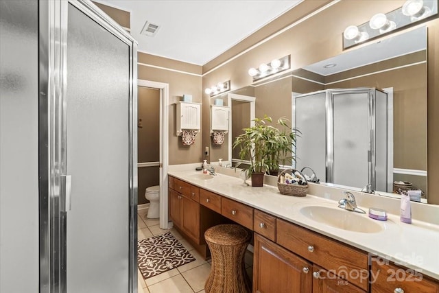 full bath with double vanity, tile patterned floors, a shower stall, and a sink