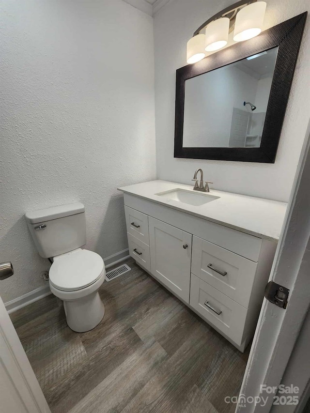 409 S Martin Luther King Jr Ave, Salisbury, NC 28144 - bathroom with vanity, toilet, baseboards, wood finished floors, and a textured wall