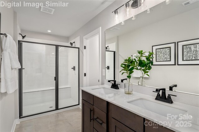 full bathroom featuring double vanity, visible vents, a shower stall, and a sink