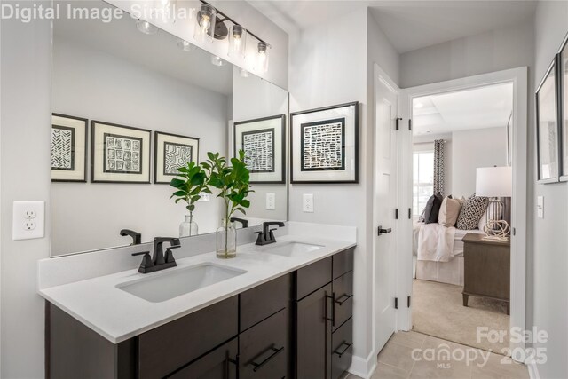 full bath featuring double vanity, tile patterned floors, a sink, and ensuite bathroom
