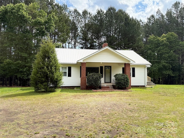 3634 Cartledge Creek Rd, Mount Gilead, NC 27306 - view of front of home featuring a porch, a front yard, a chimney, and metal roof