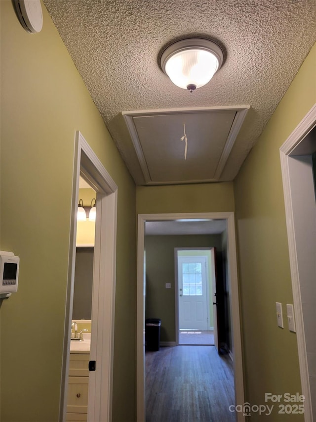 3634 Cartledge Creek Rd, Mount Gilead, NC 27306 - corridor featuring attic access, wood finished floors, a textured ceiling, a sink, and baseboards