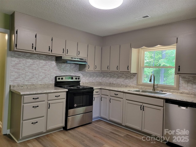 3634 Cartledge Creek Rd, Mount Gilead, NC 27306 - kitchen with a textured ceiling, visible vents, appliances with stainless steel finishes, a sink, and under cabinet range hood
