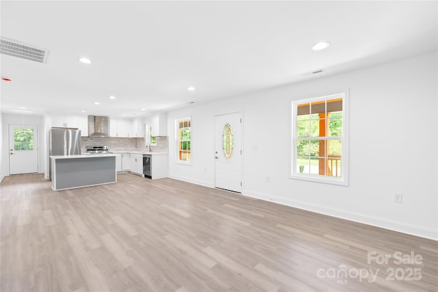 662 Camp Ferry Rd, Mooresboro, NC 28114 - unfurnished living room with recessed lighting, plenty of natural light, light wood-style floors, baseboards, and attic access