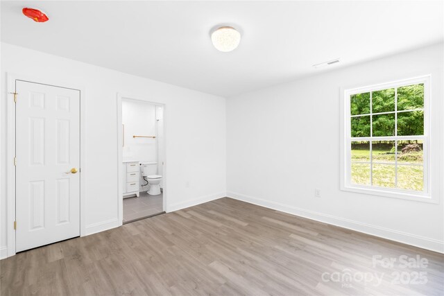 662 Camp Ferry Rd, Mooresboro, NC 28114 - unfurnished bedroom featuring wood finished floors, baseboards, and ensuite bathroom