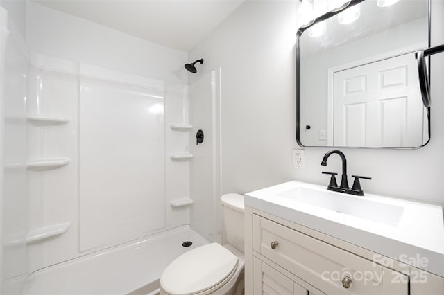 bathroom with vanity, toilet, and a shower