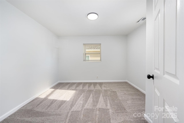 spare room with carpet floors, baseboards, and visible vents