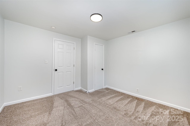 unfurnished room featuring visible vents, carpet, and baseboards