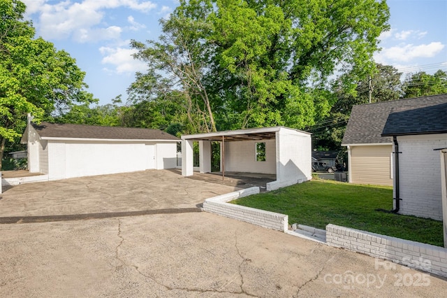 mid-century inspired home with aphalt driveway, a front yard, brick siding, an outbuilding, and a carport