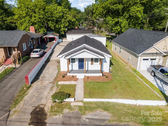 view of front of property featuring covered porch, driveway, and a front yard