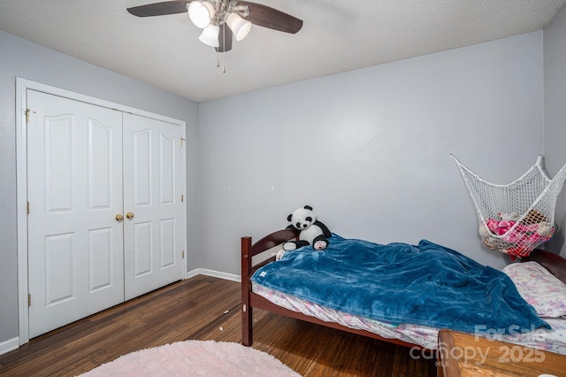 bedroom featuring a ceiling fan, baseboards, wood finished floors, and a closet