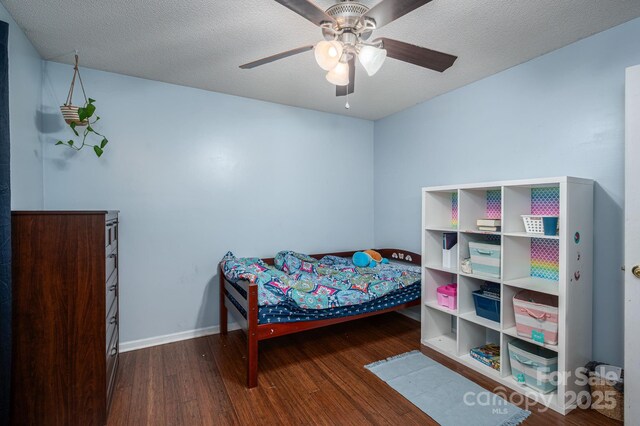 bedroom with baseboards, a textured ceiling, ceiling fan, and wood finished floors