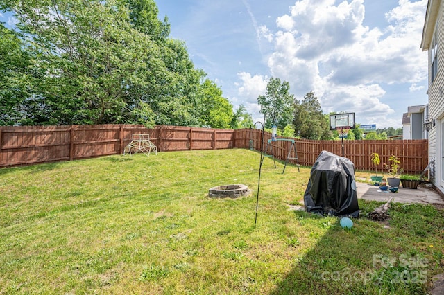 view of yard featuring a fenced backyard, a fire pit, and a patio area
