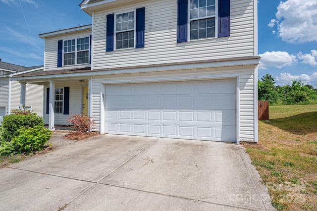 traditional home with a porch, a garage, a front lawn, and driveway