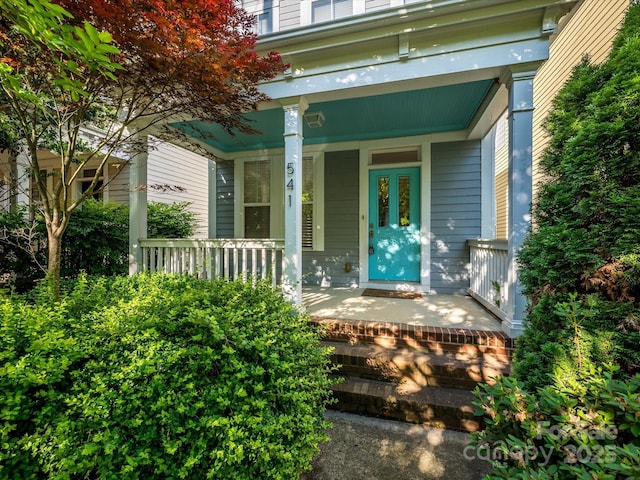 view of exterior entry featuring covered porch
