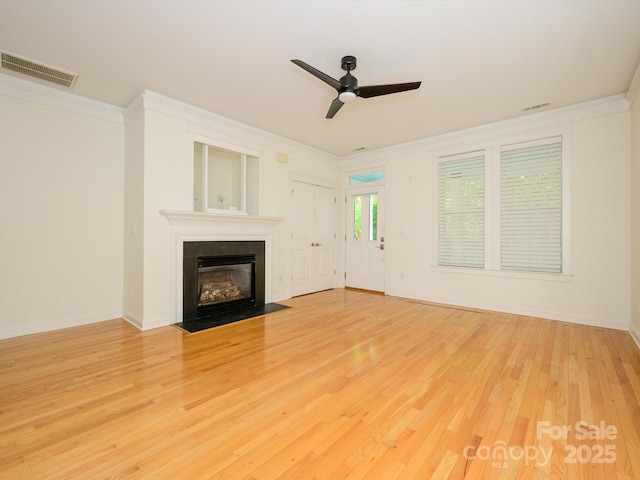 unfurnished living room featuring a tiled fireplace, visible vents, a ceiling fan, and ornamental molding