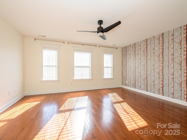 unfurnished room with baseboards, ceiling fan, and wood finished floors