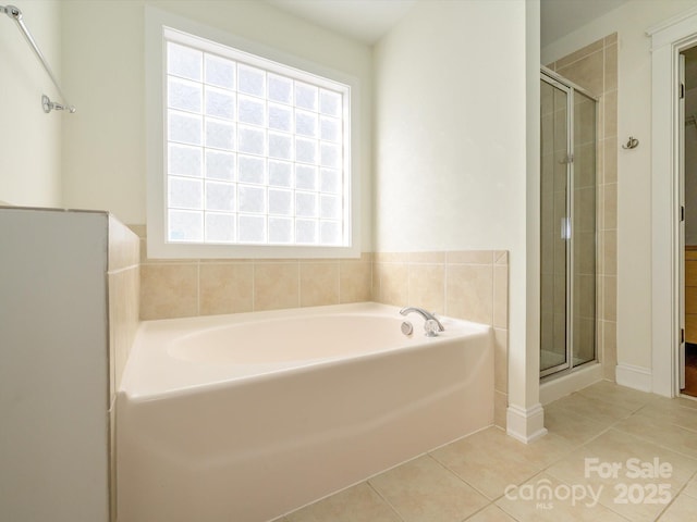 bathroom with tile patterned floors, a bath, and a shower stall