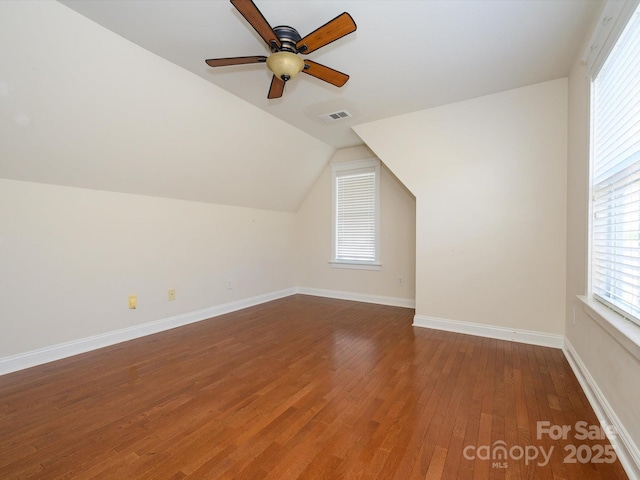 additional living space featuring baseboards, ceiling fan, visible vents, vaulted ceiling, and wood finished floors