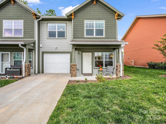 craftsman-style house with a porch, driveway, a front lawn, an attached garage, and stone siding