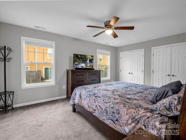 bedroom featuring baseboards, multiple windows, two closets, and visible vents