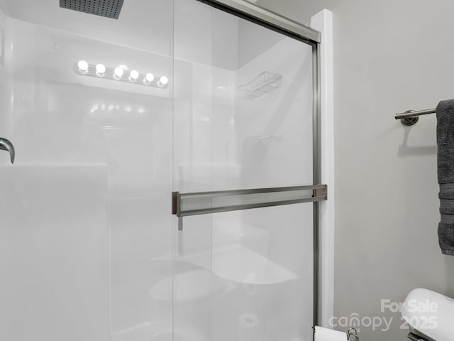 full bath featuring a shower stall and toilet