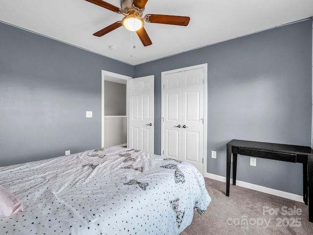 bedroom with light colored carpet, baseboards, ceiling fan, and a closet
