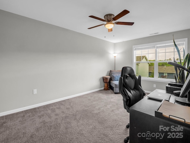 carpeted home office featuring baseboards, a ceiling fan, and visible vents
