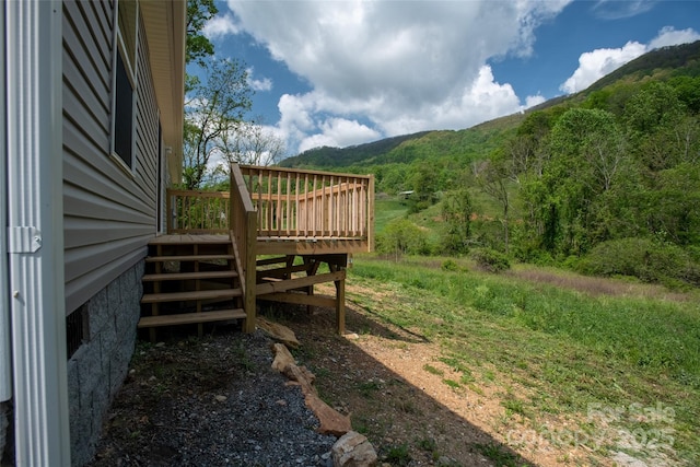 view of yard with stairs and a deck with mountain view