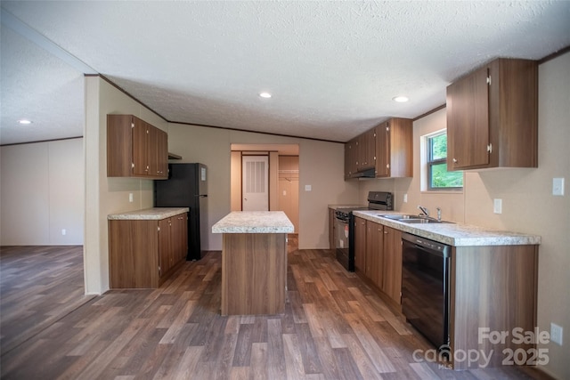 kitchen featuring a sink, black appliances, dark wood finished floors, and a textured ceiling