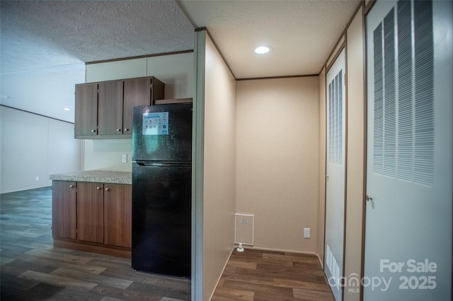 kitchen with dark wood-style flooring, a textured ceiling, light countertops, freestanding refrigerator, and recessed lighting