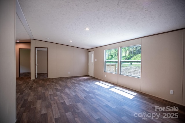 spare room featuring ornamental molding, a textured ceiling, and wood finished floors