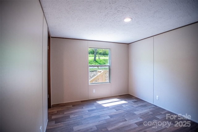 spare room featuring a textured ceiling and wood finished floors