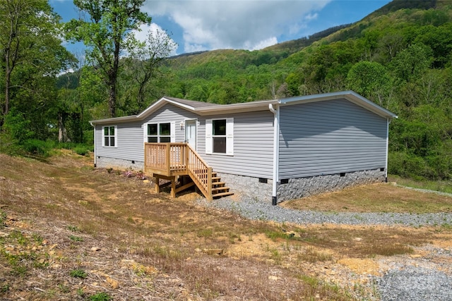 manufactured / mobile home with crawl space and a forest view