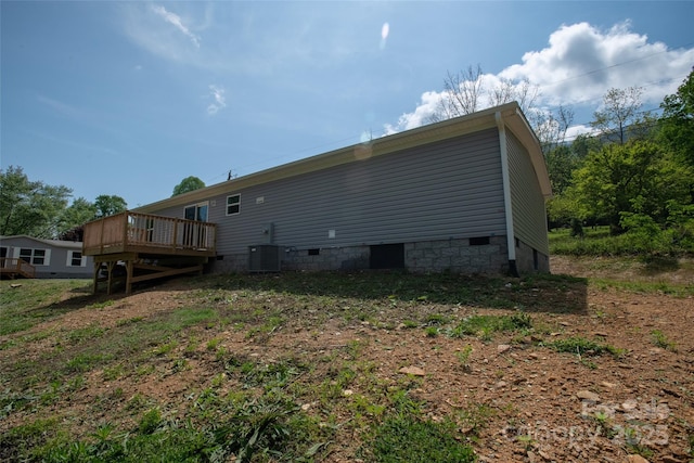 view of side of home with central air condition unit, crawl space, and a deck