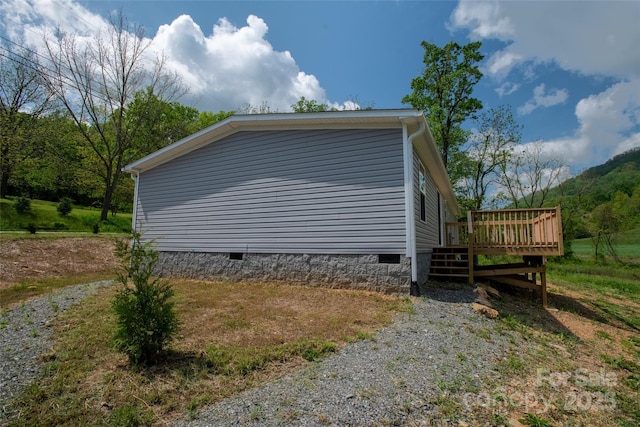 view of side of home featuring crawl space and a deck