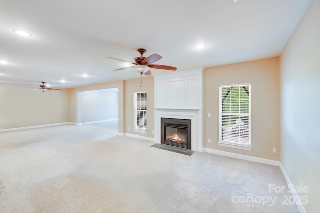 unfurnished living room with a fireplace with flush hearth, light carpet, a ceiling fan, and recessed lighting