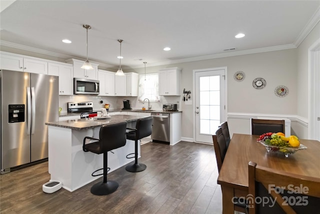 3015 Great Falls Highway, Chester, SC 29014 - kitchen featuring a breakfast bar area, dark wood-style flooring, crown molding, a sink, and stainless steel appliances