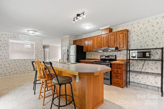 2521 Melvin Propst Dr, Morganton, NC 28655 - kitchen featuring stainless steel appliances, under cabinet range hood, wallpapered walls, a textured ceiling, and light floors