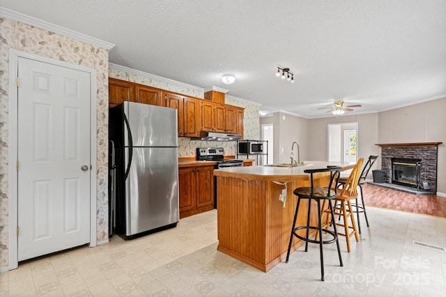 2521 Melvin Propst Dr, Morganton, NC 28655 - kitchen featuring stainless steel appliances, a sink, under cabinet range hood, ceiling fan, and light floors