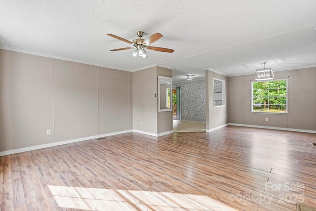 2521 Melvin Propst Dr, Morganton, NC 28655 - unfurnished living room with ceiling fan, wood finished floors, ornamental molding, a textured ceiling, and baseboards