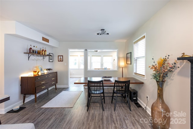 dining area featuring baseboards and dark wood-type flooring