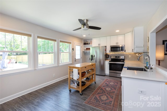 kitchen featuring ceiling fan, tasteful backsplash, a sink, light countertops, and stainless steel appliances