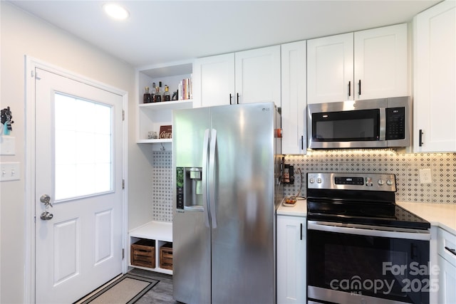 kitchen featuring white cabinets, stainless steel appliances, open shelves, and backsplash