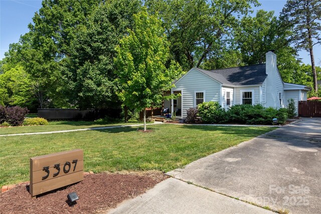 ranch-style home featuring fence, a chimney, and a front yard