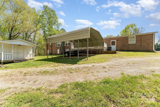 5013 Friendship Circle Rd, East Bend, NC 27018 - rear view of house with a shed, a carport, brick siding, and a lawn