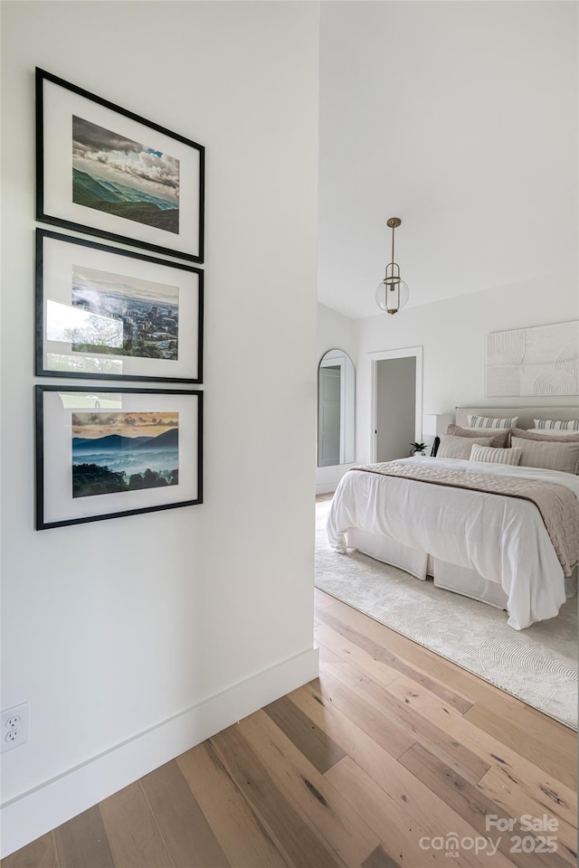 bedroom featuring baseboards and wood finished floors