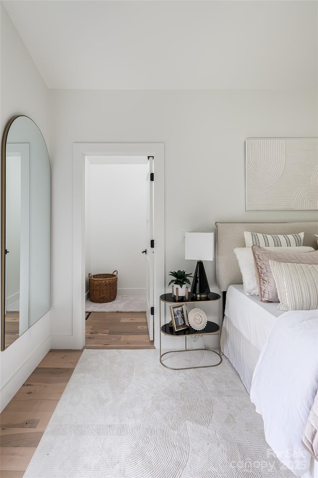 bedroom with baseboards and wood finished floors